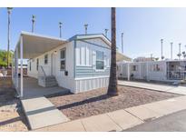 Single-wide manufactured home with covered carport and landscaped yard at 5201 W Camelback Rd # A187, Phoenix, AZ 85031