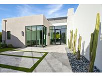 Contemporary home exterior with large windows and stone accents at 6862 E Joshua Tree Ln, Paradise Valley, AZ 85253