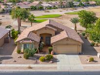 Single-story home with desert landscaping, two-car garage, and a golf course view at 109 S Agua Fria Ln, Casa Grande, AZ 85194