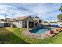 Inviting backyard oasis featuring a sparkling pool, spacious patio, and lush grass at 4112 E Tanglewood Dr, Phoenix, AZ 85048