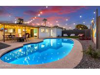 Inviting kidney-shaped pool with patio and string lights; perfect for entertaining at 2401 N 37Th St, Phoenix, AZ 85008