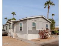 Gray manufactured home with landscaping and a carport at 625 W Mckellips Rd # 213, Mesa, AZ 85201