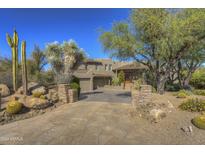 Stunning desert landscape surrounds this two-story home with a large stone driveway at 3110 Arroyo Hondo --, Carefree, AZ 85377