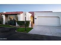 Spanish style home with tile roof, white stucco, and a two car garage at 7331 E Valley Vista Dr, Scottsdale, AZ 85250