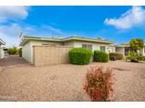 Neatly landscaped exterior of a single-story home with a gravel driveway at 9736 W Lancaster Dr, Sun City, AZ 85351