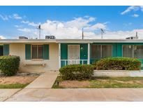 Front view of a ranch-style home with teal accents and well-maintained landscaping at 10434 W Oakmont Dr, Sun City, AZ 85351