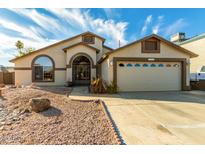 House exterior featuring a two-car garage and well-maintained landscaping at 2606 N 89Th Dr, Phoenix, AZ 85037