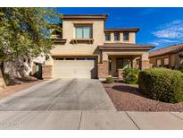 Two-story house with a beige facade, two-car garage, and landscaped front yard at 174 E Baja Pl, Casa Grande, AZ 85122