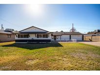 Ranch style home with a well-manicured lawn and attached garage at 6425 W Campbell Ave, Phoenix, AZ 85033