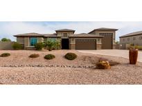 One-story home with a three-car garage and desert landscaping at 6523 N 135Th Dr, Glendale, AZ 85307