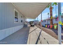 Mobile home exterior with covered carport and golf cart at 2701 E Allred Ave # 136, Mesa, AZ 85204