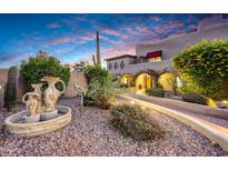 Landscaped front yard with fountain and pathway leading to the entrance of a Spanish-style home at 6945 E Ashler Hills Dr, Scottsdale, AZ 85266