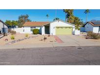 Charming single-story home with a green garage door and desert landscaping at 9330 E Kalil Dr, Scottsdale, AZ 85260