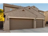 Two-story house with three car garage and desert landscaping at 11867 W Grant St, Avondale, AZ 85323