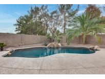 Inviting kidney-shaped pool with a stone waterfall feature at 1522 S Dove St, Gilbert, AZ 85233