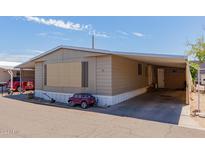 Tan single-wide manufactured home with carport and small yard at 2121 N Center St # 73, Mesa, AZ 85201