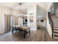 Bright dining room features a large wooden table, six chairs, and a modern chandelier at 49 S Ocean Dr, Gilbert, AZ 85233