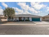 Single-story home with green garage door and landscaped front yard at 13023 W Skyview Dr, Sun City West, AZ 85375