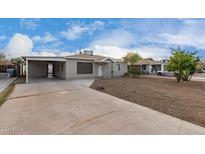 Front view of the house with driveway and landscaping at 1825 W Roma Ave, Phoenix, AZ 85015