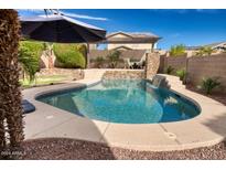 Refreshing kidney-shaped pool with waterfall feature at 2213 N Park Meadows Dr, Buckeye, AZ 85396