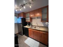 Modern kitchen features stainless steel appliances and wood cabinets at 6125 E Indian School Rd # 164, Scottsdale, AZ 85251