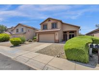 Two-story house with tan exterior, two-car garage, and landscaped front yard at 18110 N Skyhawk Dr, Surprise, AZ 85374