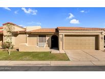 Tan stucco house with a two-car garage and grassy front yard at 1021 S Greenfield Rd # 1043, Mesa, AZ 85206