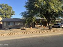 Ranch style home with brick facade, mature landscaping, and a two-car garage at 4550 W Bloomfield Rd, Glendale, AZ 85304