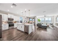 Open concept kitchen boasts stainless steel appliances and an island at 26001 W Matthew Dr, Buckeye, AZ 85396