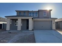 Two-story home with gray exterior and stone accents, featuring a three-car garage at 7383 W Whitehorn Trl, Peoria, AZ 85383