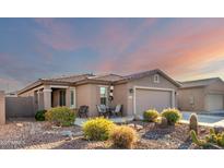 Single-story home with desert landscaping and two-car garage at 11009 W Wikieup Ln, Sun City, AZ 85373