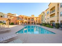 Community pool with lounge chairs and BBQ grills at 14575 W Mountain View Blvd # 11309, Surprise, AZ 85374