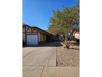 House exterior featuring a driveway, landscaping, and a garage at 5738 N 68Th Ave, Glendale, AZ 85303
