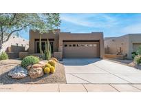 Single-story home with desert landscaping and a two-car garage at 9573 E Chuckwagon Ln, Scottsdale, AZ 85262