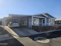Gray exterior of manufactured home with carport and landscaped yard at 650 N Hawes Rd # 3729, Mesa, AZ 85207