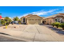 Tan house with tile roof, two-car garage, and desert landscaping at 123 S Cobblestone Dr, Gilbert, AZ 85296