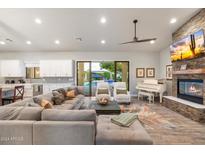 Spacious living area featuring a fireplace, large TV, and access to the pool at 115 S Galaxy Dr, Chandler, AZ 85226
