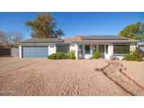 Ranch home with solar panels, attached garage, and landscaped front yard at 14410 N 42Nd Pl, Phoenix, AZ 85032