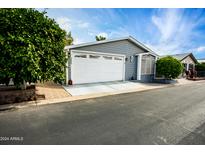Gray exterior of manufactured home with white garage door and landscaped yard at 650 N Hawes Rd # 2840, Mesa, AZ 85207