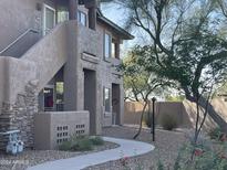 Well-maintained stucco building with a curved walkway, landscaping, and mature trees at 11500 E Cochise Dr # 1030, Scottsdale, AZ 85259