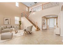 Bright living room with high ceilings and an open staircase at 12006 W Vernon Ave, Avondale, AZ 85392