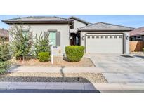Single-story home with a two-car garage and well-maintained landscaping at 16406 W Charlotte Dr, Surprise, AZ 85387