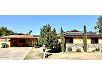 Ranch style home with solar panels, mature landscaping, and a paved driveway at 404 E Paseo De Isabella --, Casa Grande, AZ 85122