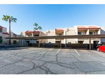 Exterior view of condo building with assigned parking spaces under covered carport at 1401 E Puget Ave # 24, Phoenix, AZ 85020