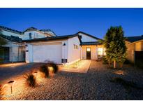 Stunning curb appeal with modern farmhouse exterior, landscaping, and lighting at 17221 W Middlebury St, Surprise, AZ 85388