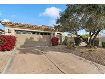 Tan stucco house with two-car garage and nicely landscaped front yard at 7979 E Princess Dr # 13, Scottsdale, AZ 85255