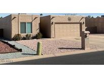 Tan stucco house with a two-car garage and a landscaped front yard at 9346 E Citrus N Ln, Sun Lakes, AZ 85248