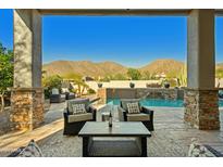 Stunning backyard oasis with a sparkling pool, mountain views, and comfortable seating at 11696 E Charter Oak Dr, Scottsdale, AZ 85259