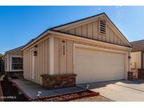 Tan house with a two-car garage and well-maintained landscaping at 18803 N 33Rd Dr, Phoenix, AZ 85027