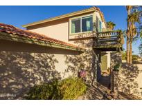 Exterior view of a two-story house with a walkway, landscaping, and a balcony at 9411 S 45 Pl, Phoenix, AZ 85044